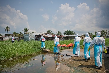 Red Cross workers remove a body for a safe and dignified burial during Ebola outbreak