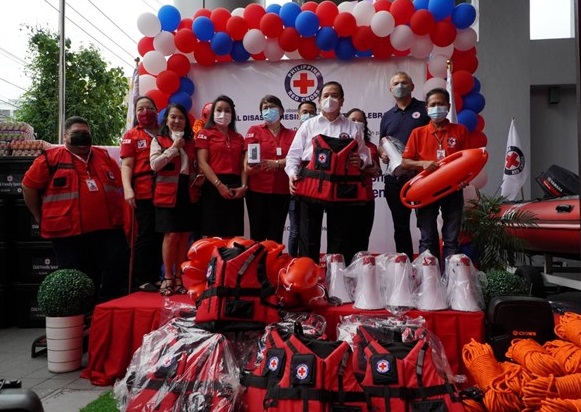 Philippine Red Cross key members pose for photos on stage, with the emergency response equipment on display.