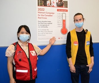 Canadian Red Cross volunteer and Walmart Ambassador Ha Vu, pictured with Walmart associate Nicholes Buksinski in front of a campaign sign at the Dartmouth Crossing store in Nova Scotia