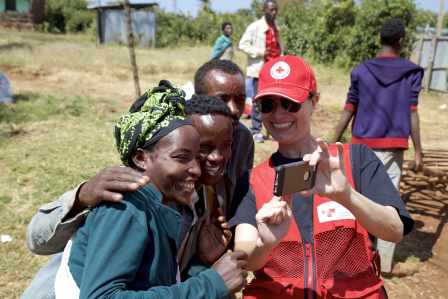 Canadian Red Cross aid worker Norine Naguib takes a selfie with people gathered to receive supplies