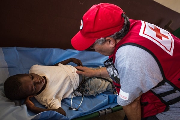 Canadian Red Cross mobile clinic doctor, Jamal Serrar, performs an abdominal palpation exam