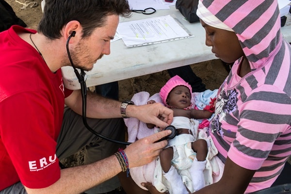 Canadian Red Cross mobile clinic nurse Francis Duclos examines 20-day old newborn