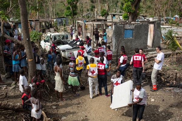 Local Haitian Red Cross volunteers and ERU mobile clinic members set up ERU mobile clinic.