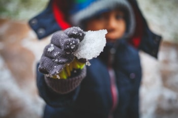 Child holding snow