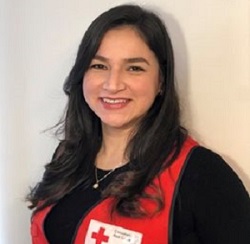 A woman in a Red Cross vest smiling at the camera