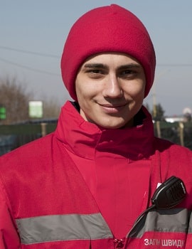 A man standing in a red toque and Red Cross vest
