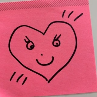 A pink post-it note with a heart in black marker drawn on it.
