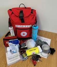 A Canadian Red Cross emergency kit with contents displayed in front.