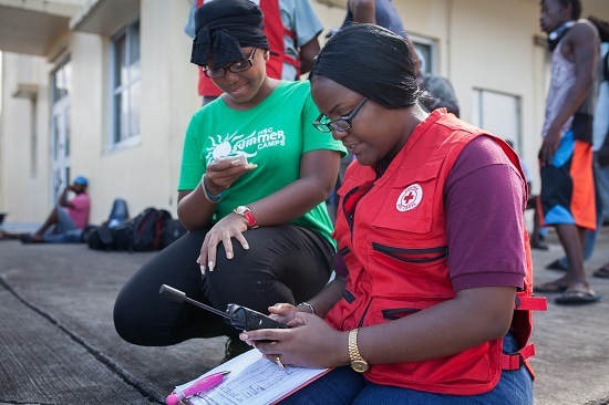 A Dominica Red Cross aid worker uses a satellite phone