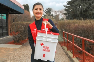 Red Cross volunteer holding Red Cross bucket