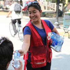 red cross volunteer distributing water bottles