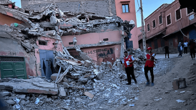 Members of the Moroccan Red Crescent next to a house destroyed by the earthquake