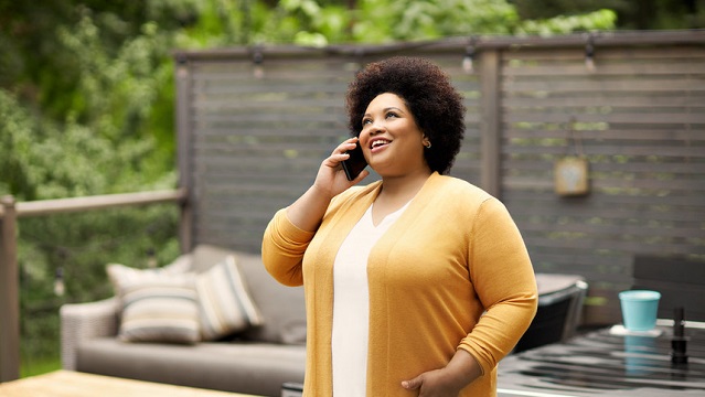 Woman talking on phone in backyard
