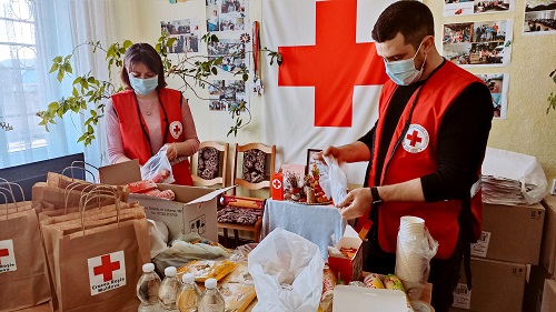 Two Red Cross volunteers packing supplies
