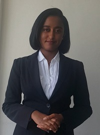 Woman with dark hair, in blue suit and white collared shirt
