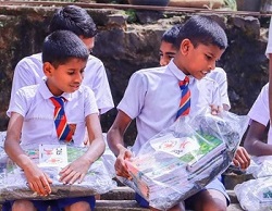 young boys in school uniforms holding new backpacks