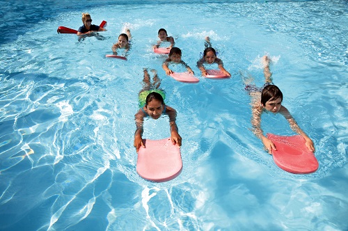 kids using float boards in a pool