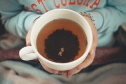a cup of coffee held in hands