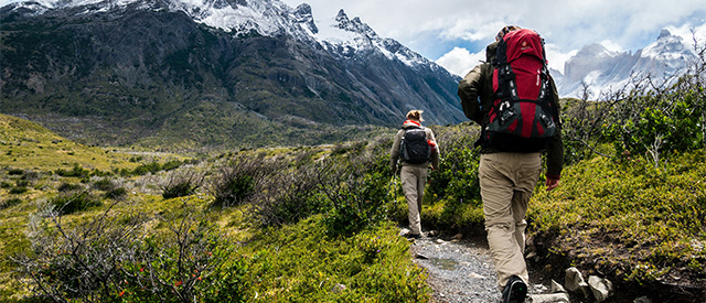 Two hikers walking up a path in the wilderness