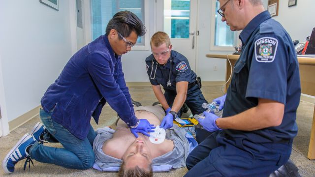 Three paramedics assisting an individual suffering from opiod poisoning
