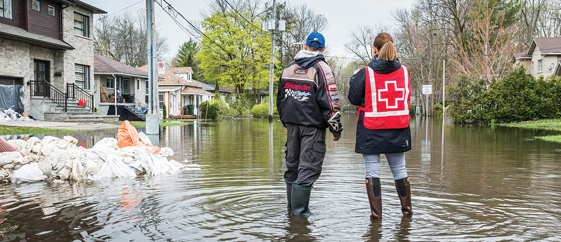 Flooding occurred in Laval, in May 2017. Two people standing on the water looking at houses.