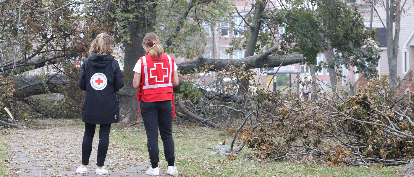 CRC volunteer standing in a flooded neighbourhood.