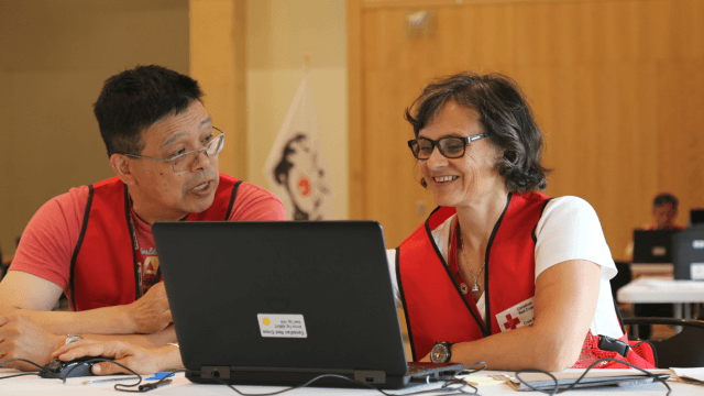 Two Canadian Red Cross volunteers working together using a laptop