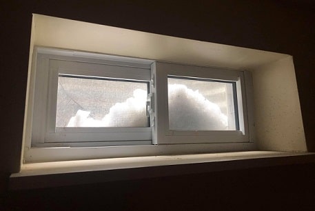Small window with mounds of snow visible outside