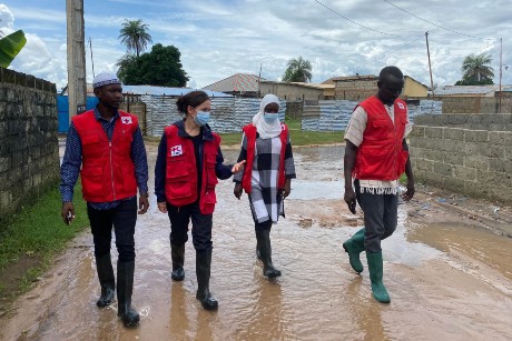Sarah Parisio walking in flooded water with 3 Red Cross members