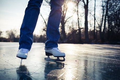 legs wearing figure skates on an outdoor rink