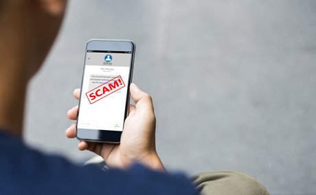 A phone screen labels a text as a scam