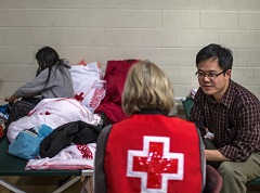 Canadian Red Cross volunteer speaks to a beneficiary 