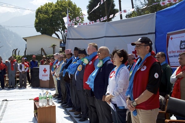 Red Cross staff stand for the national anthem