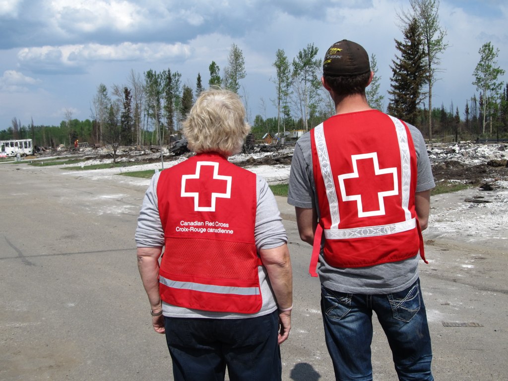  Canadian Red Cross volunteers survey damage caused by Alberta wildfires.