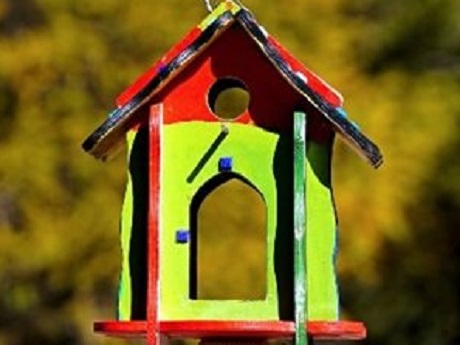 A yellow and red painted bird house