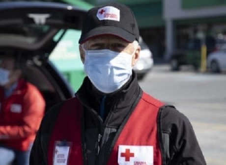 Bernard standing in a cap, mask and red vest