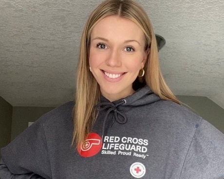 A young woman, named Kailee, smiling in her Red Cross lifeguard sweater