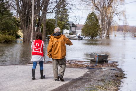 Two people walking towards a flooded area.
