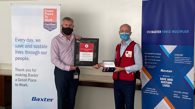 Stephen Thompson of Baxter Canada presents Ronan Ryan of Canaidan Red Cross with a plaque. 
