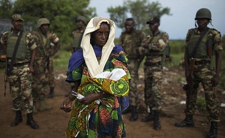 A woman holds her baby in her arms.