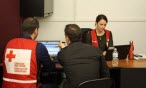 Red Cross worker helping on a computer