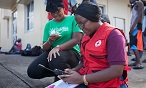 A Dominica Red Cross aid worker uses a satellite phone