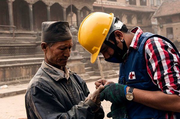 Nepal Red Cross volunteer provide care to Nepali man