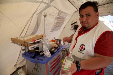 A Red Cross aid worker organizes bags.