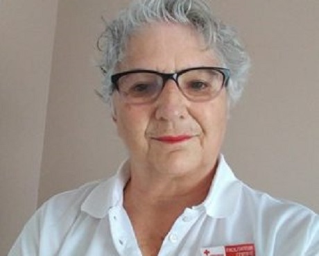 Marie standing in a white shirt with Red Cross pin
