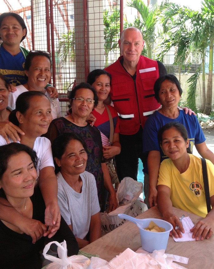 Conrad Sauvé, Canadian Red Cross Secretary General, meets local residents at a distribution centre in Cebu