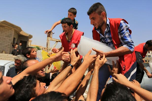 Iraqi Red Crescent volunteers distribute relief items