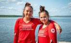 two female red cross workers standing by water