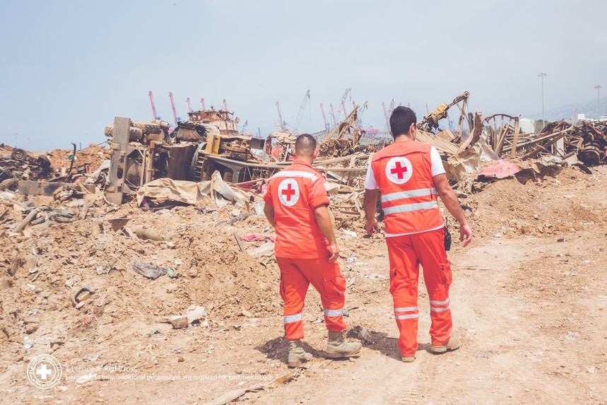 Lebanese Red Cross workers walk away from the camera, responding to explosion.