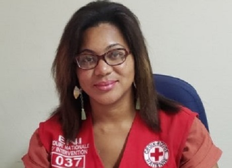 A woman in a Red Cross vest sitting in a chair